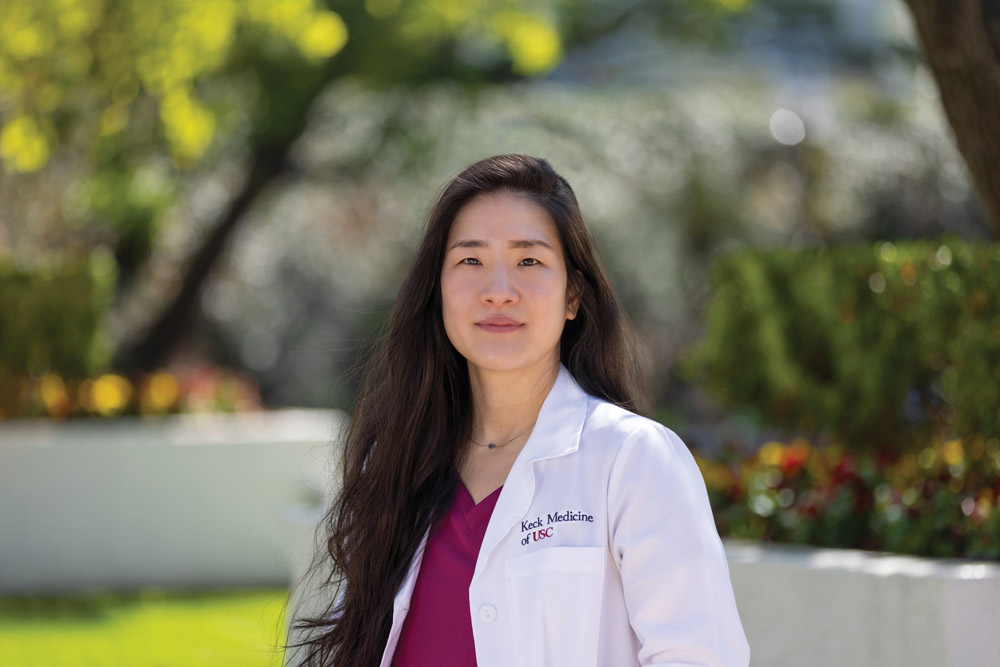 Nurse practitioner Jinseo Choi stands outside in a white Keck Medicine lab coat