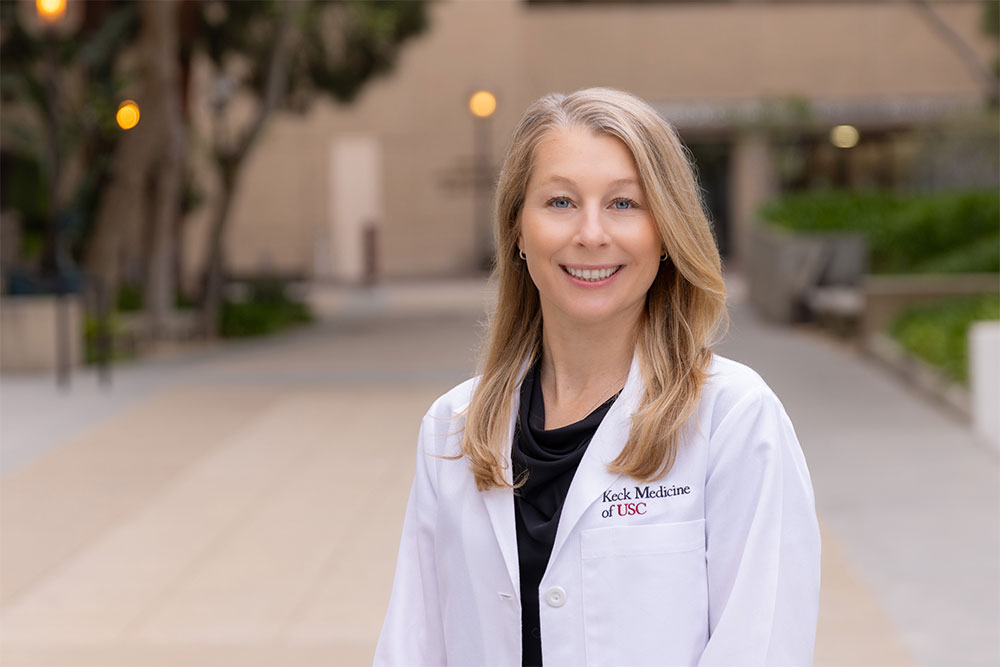 A portrait of Kristina Voss standing outside in a white coat.