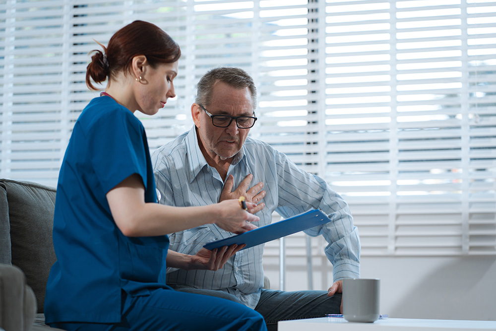 Elderly depressed male medical patient speaks with a physician or psychiatrist in doctor’s office.